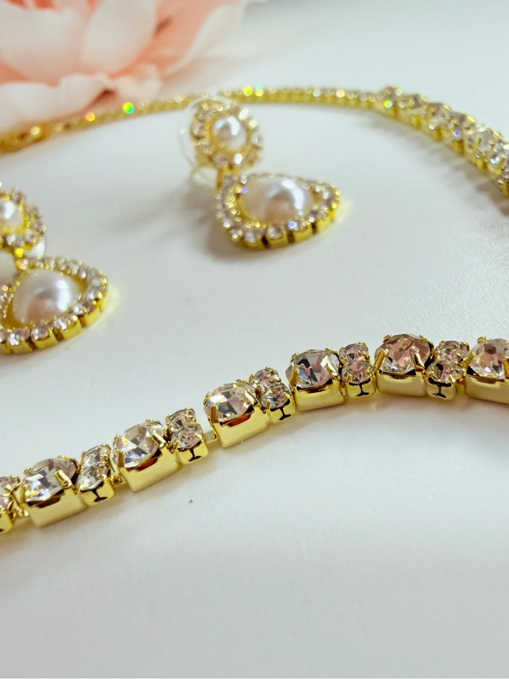 Elegant gold-tone necklace with earrings featuring a white teardrop pearl pendan
